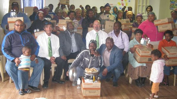 Umzamowethu community members with their stoves. With them are (seated from left) Ward 1 Councillor Zolani Mayoni, Willem van Rijswijck(Prism), Portfolio Councillor Phumzile Oliphant, Clive Pengelly and Kaneko Chauke of Prism Power, Umzamowethu Fishing Coop’s Sakhumzi Shoco and Kouga Rural Development Officer Malibongwe Dayimani (kneeling).