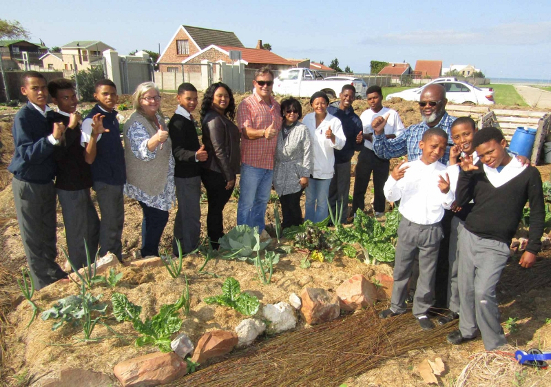 (Front right) J-Bay High School learners Quintin Swarts, Nealon Plaatjies and Shavandre Frans (all 14 years old) show outgoing LED Portfolio Councillor, Phumzile Oliphant, the vegetable garden that is being cultivated at their school, with the support of Vlakteplaas Quarry. They were joined by (back) fellow learners, the Vlakteplaas team and members of the municipality’s LED directorate.